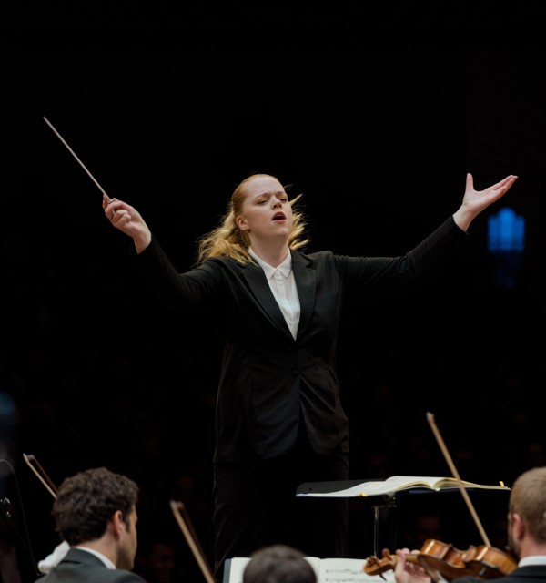 Foto av alumni Ingunn Hagen, som dirigerer. 