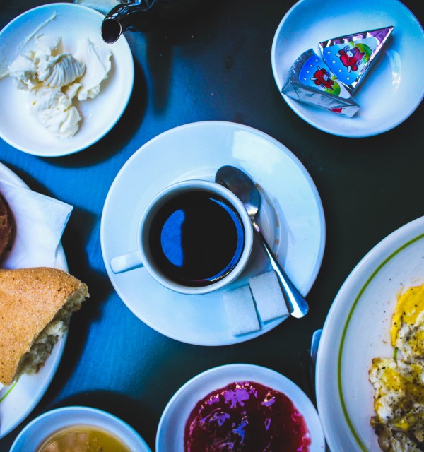 Foto tatt ovenfra av et bord dekket med frokostmat og en kaffekopp. 