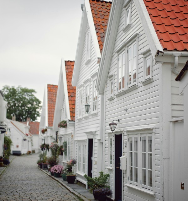 Gate med små hvite hus med røde tak og brostein på bakken.