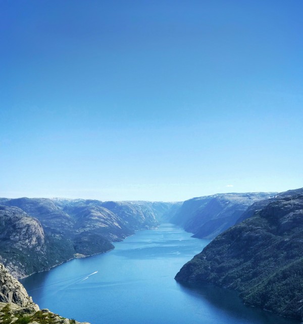 Overblikk over en fjord og skyfri himmel