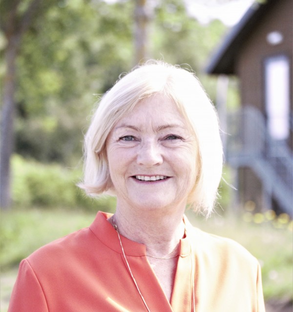Smilende kvinne med rød skjørte og lyst hår