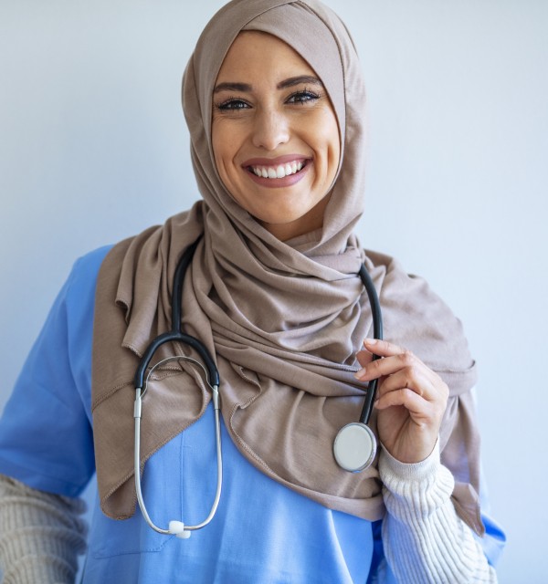 Kvinnelig lege med hijab smiler til fotografen