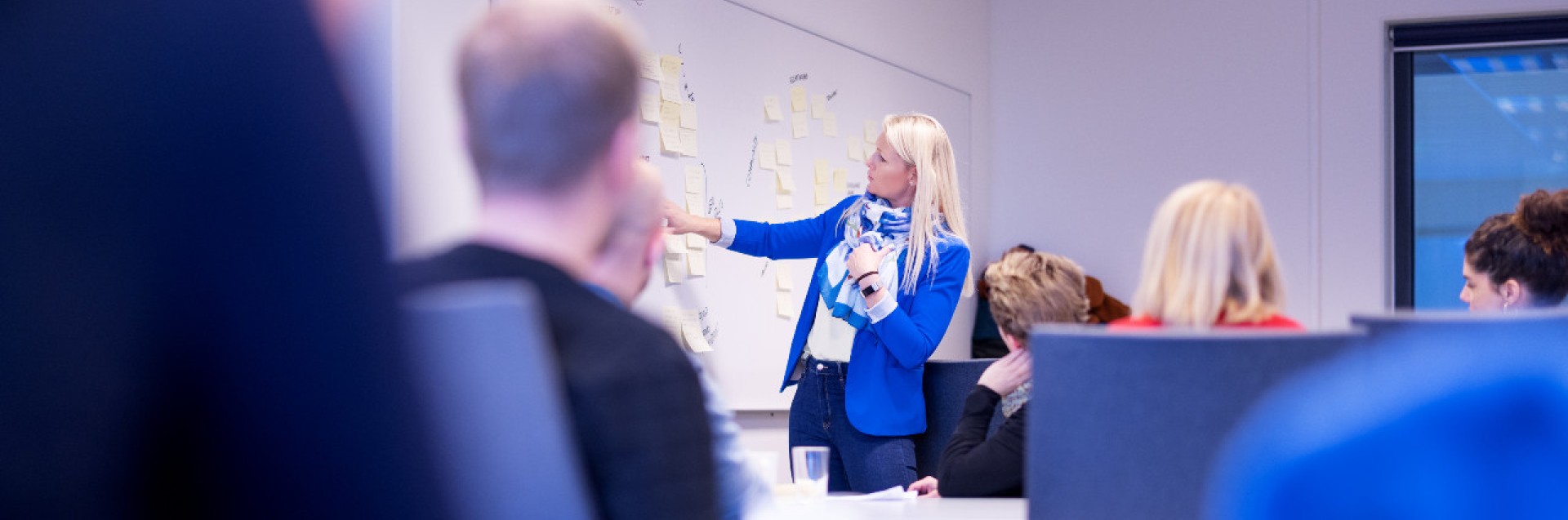 Klasserom med foreleser som peker på whiteboard