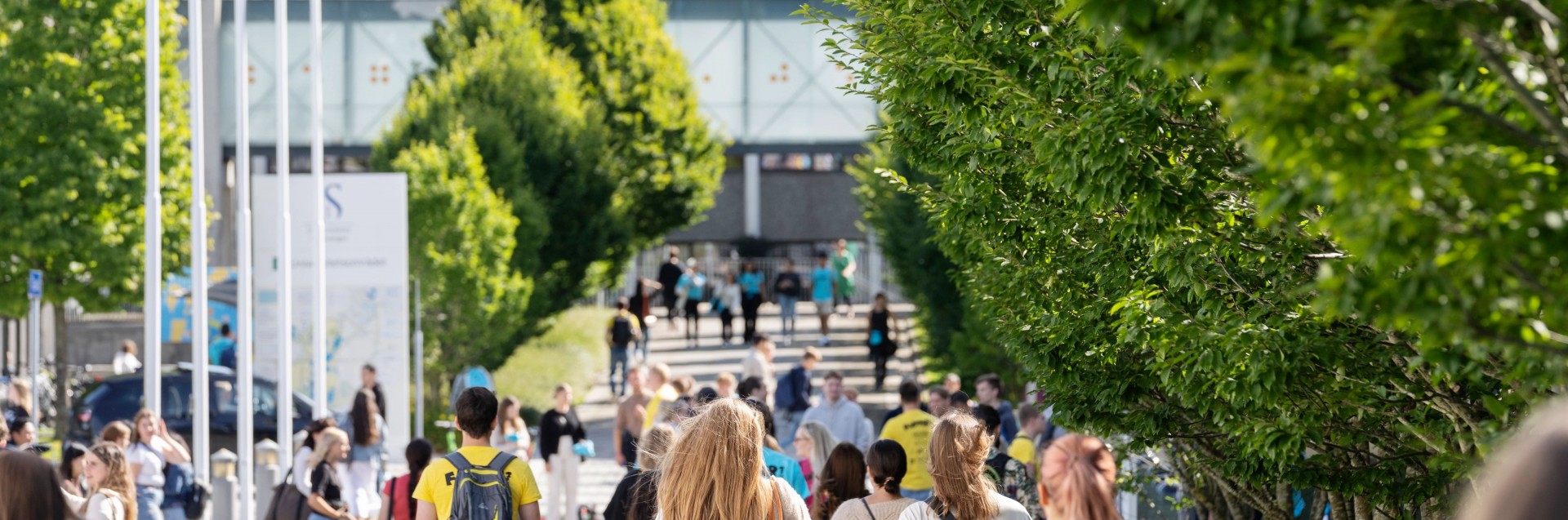 Mange studenter gående utendørs på campus Ullandhaug.