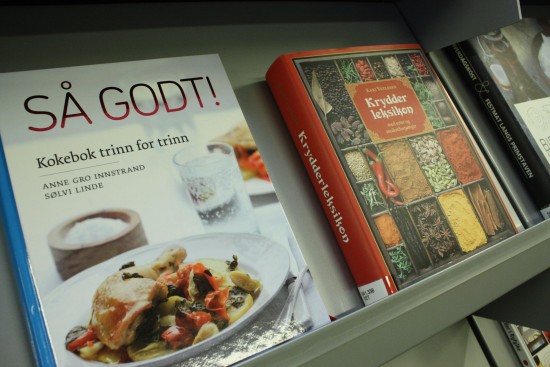 To kokebøker i en bibliotekshylle.