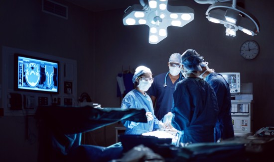 Tre helsearbeidarar ved operasjonsbordet.