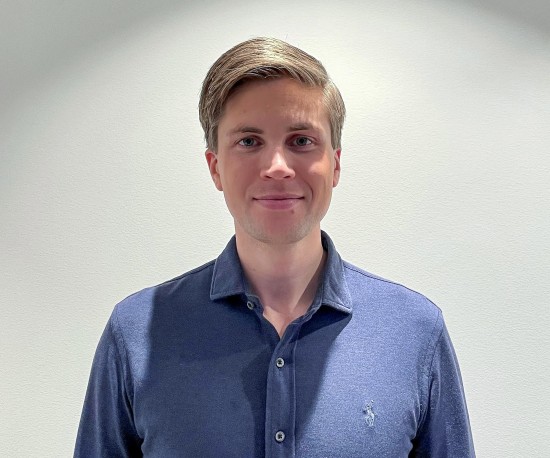 Ung mann i blå skjorte ser rett i kamera