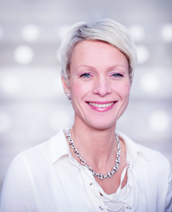 Bildet viser ansattbildet til Siri Wiig, som smiler bredt med en uskarp bakgrunn.