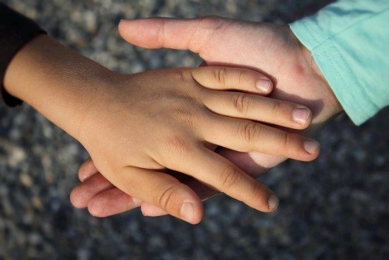 En voksen hånd holder en barnehånd.