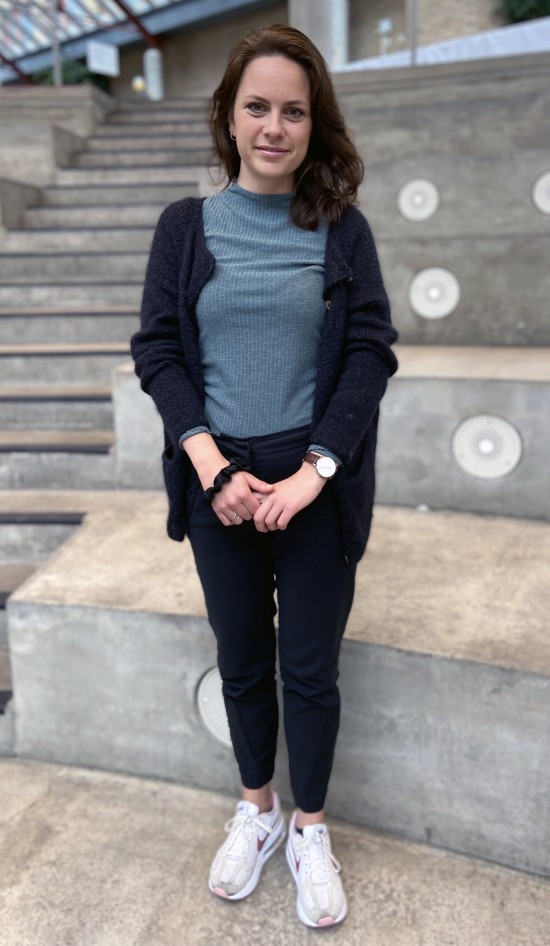 Smilende kvinne med foldede hender