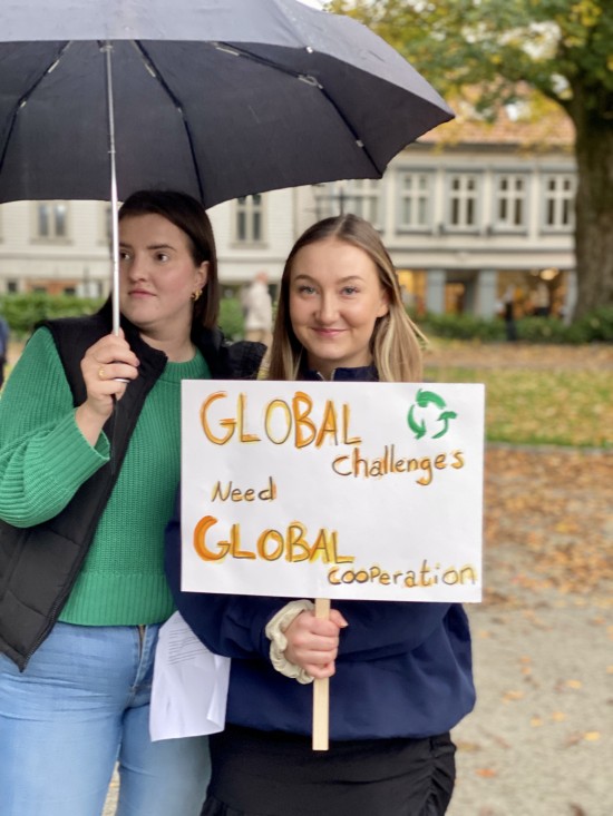 To studenter demonstrere med plakat i Byparken
