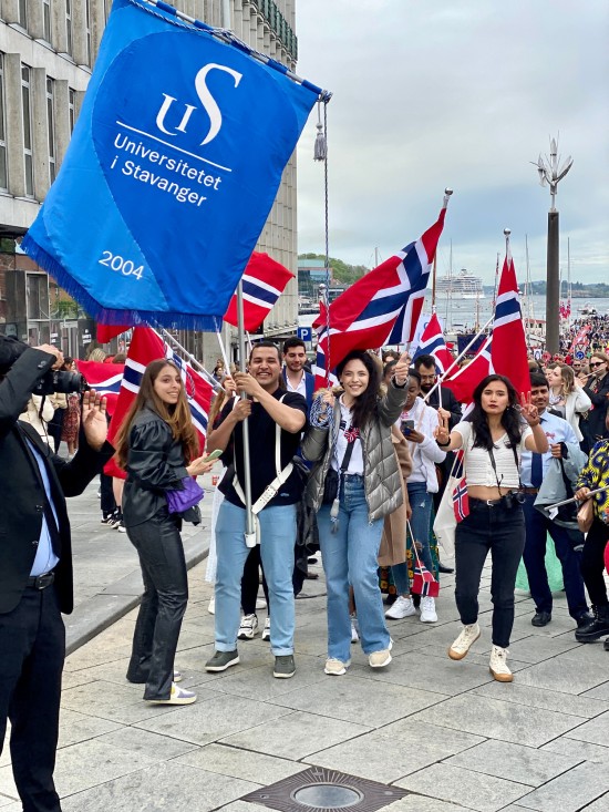 En gruppe mennesker med fane og norske flagg