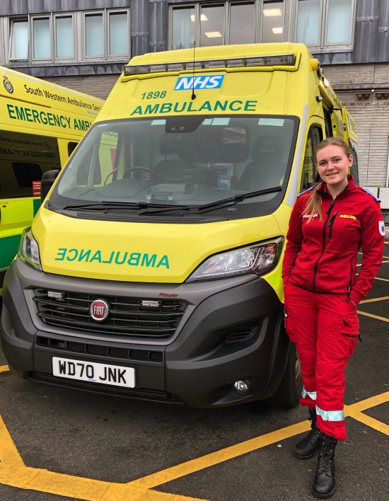 Bildet viser Emilie Røkaas i uniform foran en ambulanse i den engelske byen Plymouth.