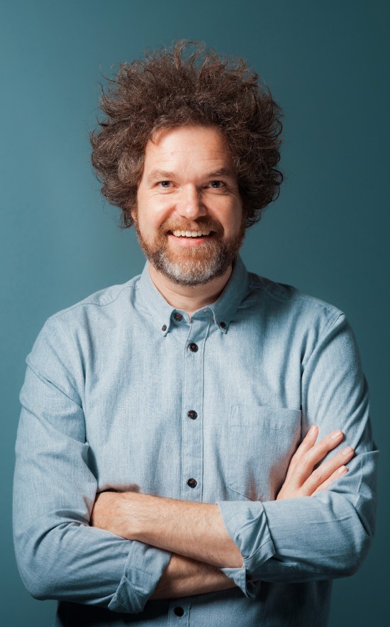 Bildet viser professoren som er omtalt i saken med et bredt smil og armene i kryss.
