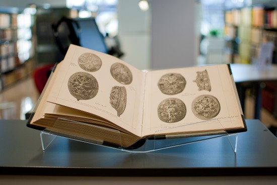 Åpen bok med bilder av arkeologiske gjenstander