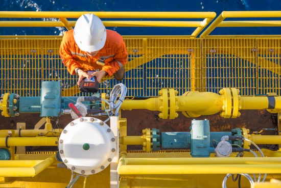 Flerkompetansebetjeningstekniker kalibrerer oljefeltet instrument, Coriolis flowmåler og aktuert styreventil på offshore olje- og gassplattform. Foto: Shutterstock