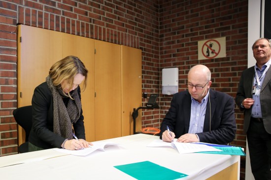 Merete Vadla Madland og Arvid Nesse signerer samarbeidsavtalen. I bakgrunnen instituttleder Tor Henning Hemmingsen.