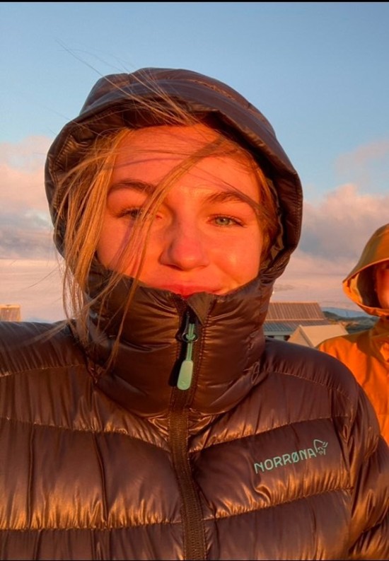 Student Camilla Ringhagen er ute en vinterdag i solnedgang. Det er kaldt, det blåser og hun har trukket den svarte boblejakken godt opp i ansiktet og trukket hetta over hodet. 