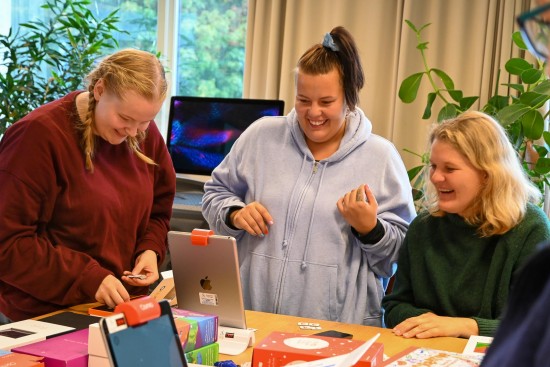 Tre kvinner studerer digitale verktøy som kan brukes i barnehage