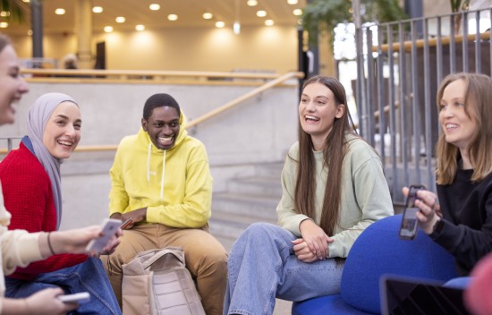 Studenter som sitter sammen og prater og ler.