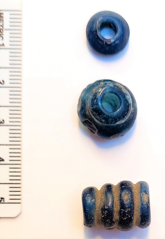 De tre blå glassperlene til Frafjord-kvinnen er fra eldre jernalder og dermed flere hundre år eldre enn de andre perlene. (Foto: Arkeologisk museum, UiS)