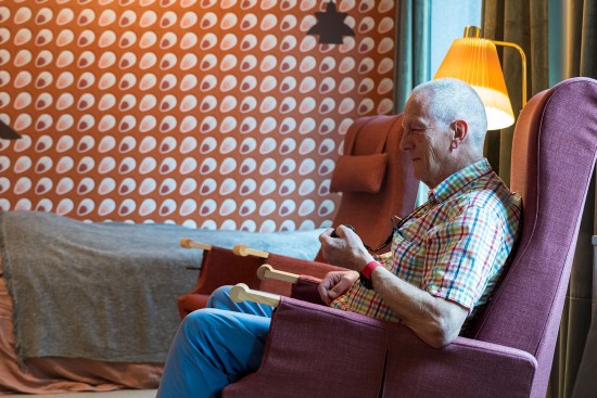 Eldre mann i hjemmemiljø med sensor i hånden