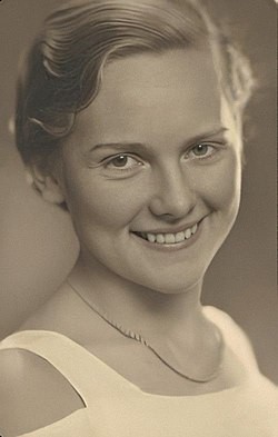svart-hvitt bilde av smilende kvinne som ser i kamera