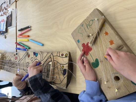 To sett barnehender som jobber med å lage instrument av planker og tråd