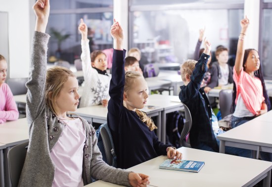 elever rekker opp hånda i klasserom