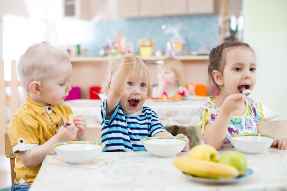 Barn i barnehage sitter ved bordet og spiser