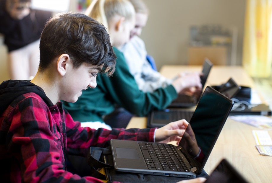 Barneskoleelever jobber på bærbar PC i klasserom