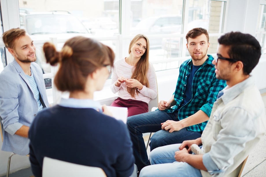 Dem studenter snakker sammen i en gruppe.