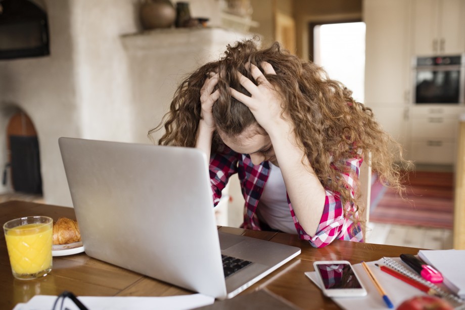 Ungdom sitter fortvilet foran en pc.