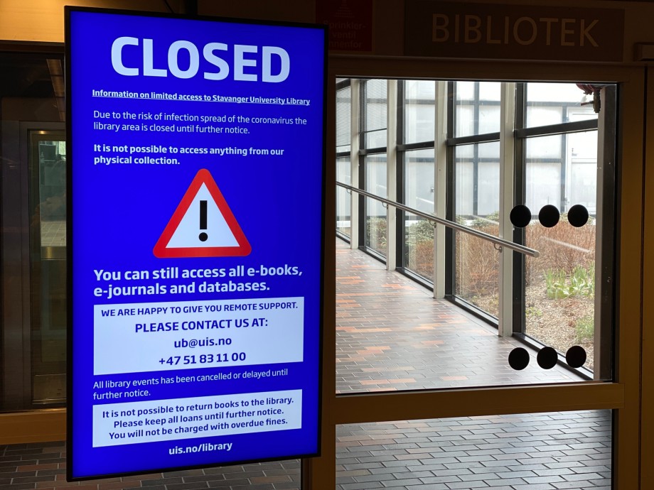 Skilt sier "CLOSED" foran inngang til universitetsbiblioteket på UiS