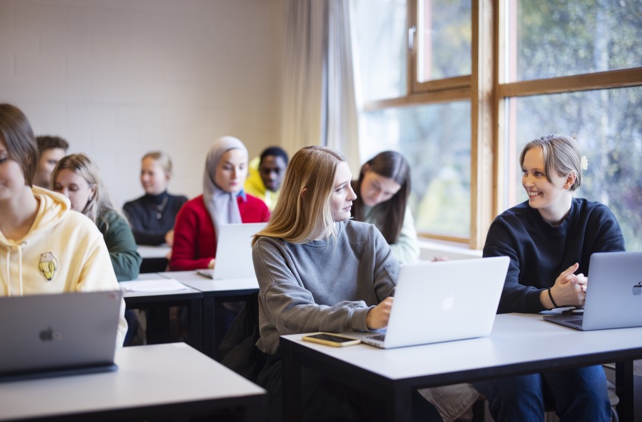 Studenter sitter ved laptoper i et klasserom.