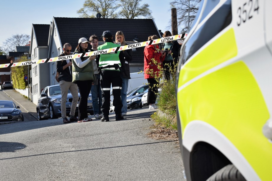 Politibil og sperrebånd foran journalistikkstudenter som intervjuer innsatsleder.