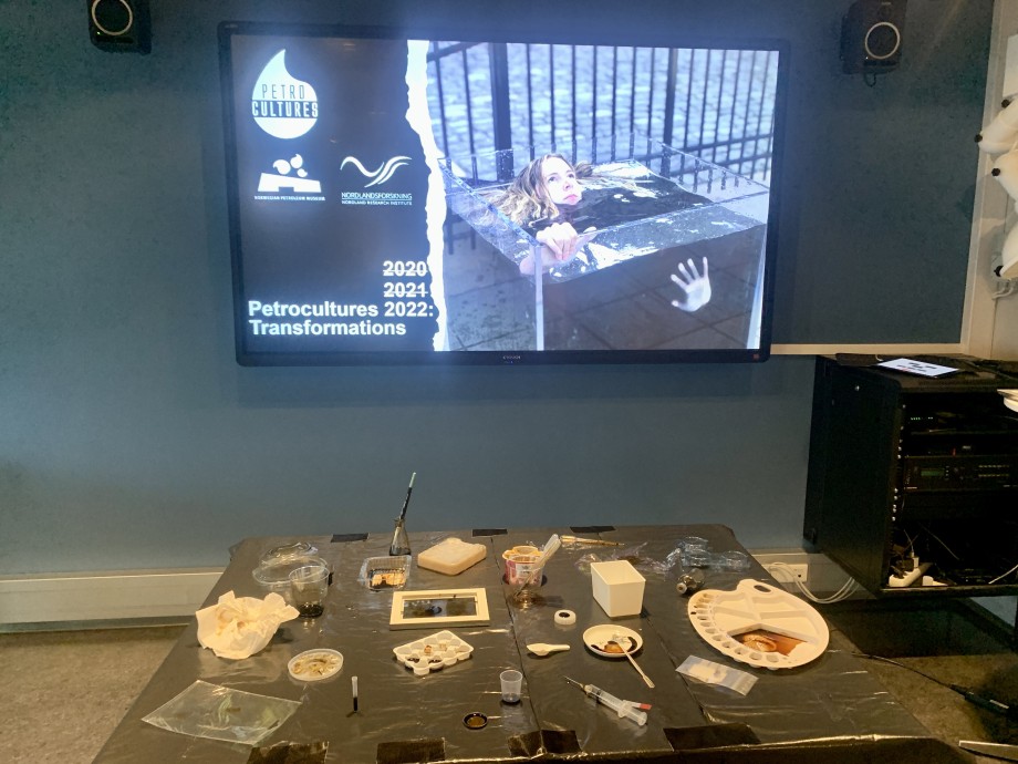 Digital display and a table of plastic artefacts from the Petrocultures conference 2022