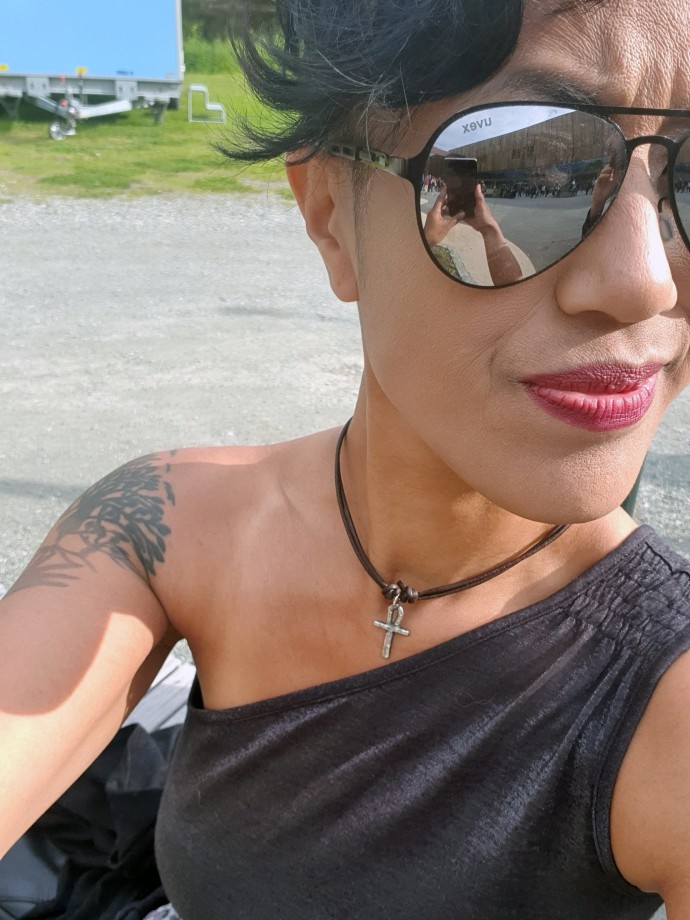 Kvinne med solbriller og tatoveringer.