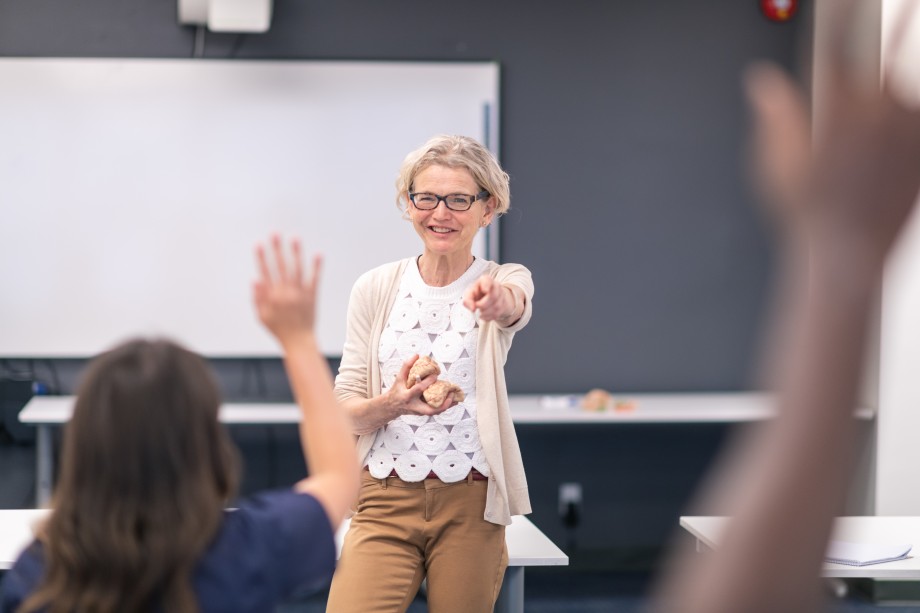 Kvinnelig lærer peker på en elev som har rekket opp hånda