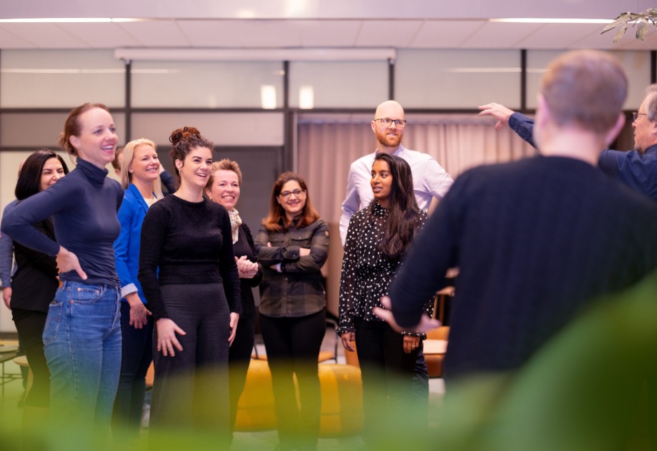 Gruppe med studenter som smiler under en gruppeaktivitet.