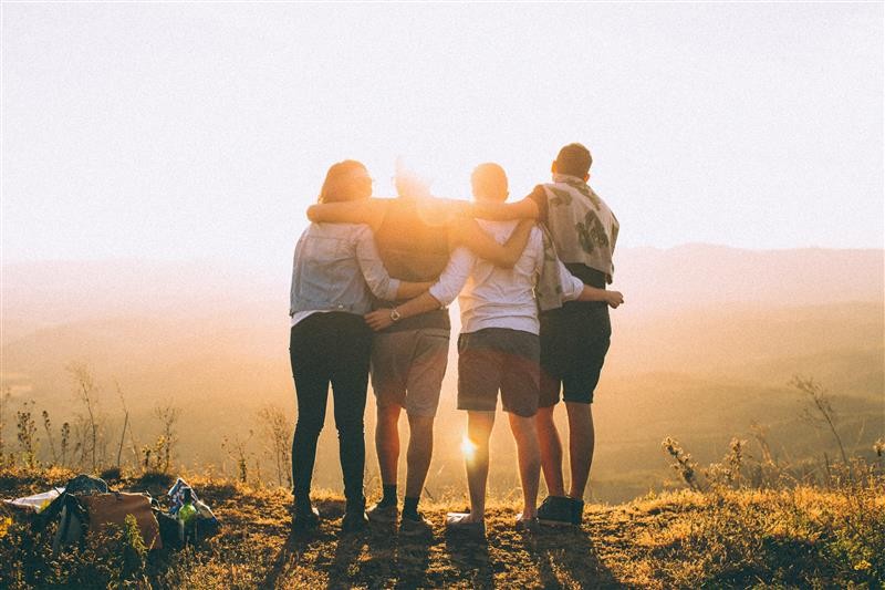 Studenter som klemmer i solnedgang
