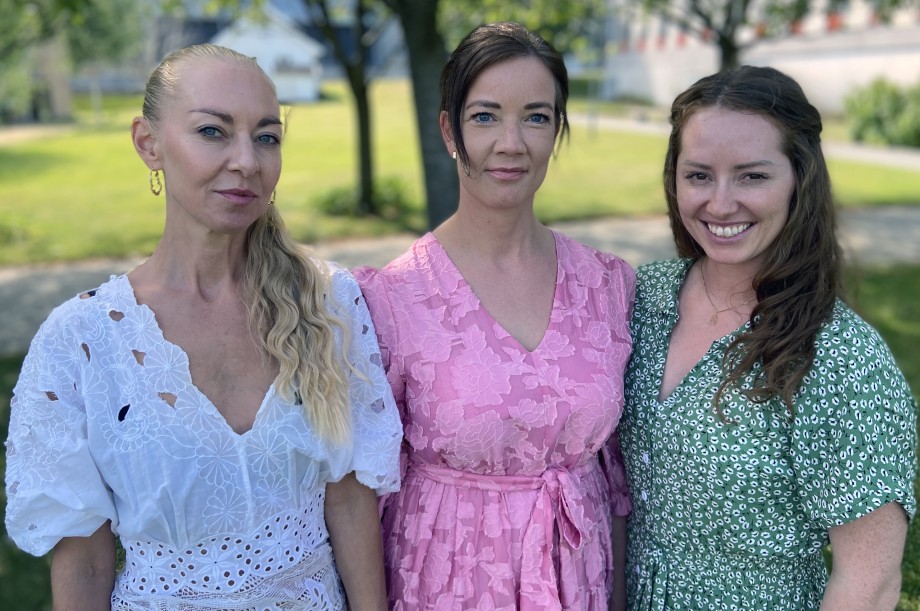 Tre kvinnelige studenter i sommerkjoler.