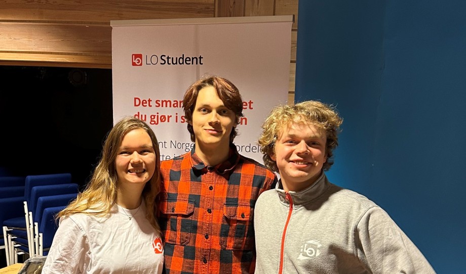 De tre listekandidatene for Sosialdemokratisk liste ved studentvalget 2023 - Susan Myrseth Vistnes, Marcus Parra Nygård og Steffen Johannesen - står foran en LO Student rollup.
