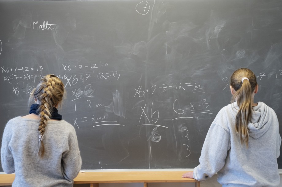 Elever jobber med matematikk på tavle