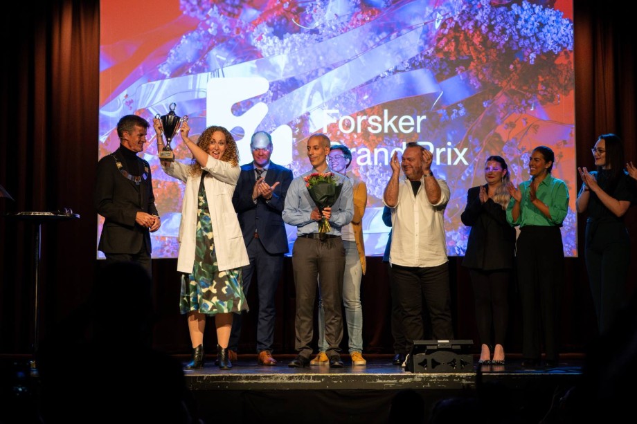 Flere folk på scenen. En holder en pokal.
