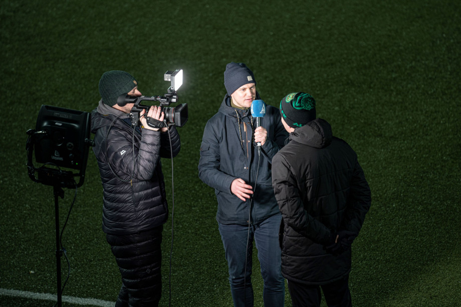 Tre personer er på bildet: en videofotograf, en journalist med mikrofon og en person blir intervjuet og filmet.