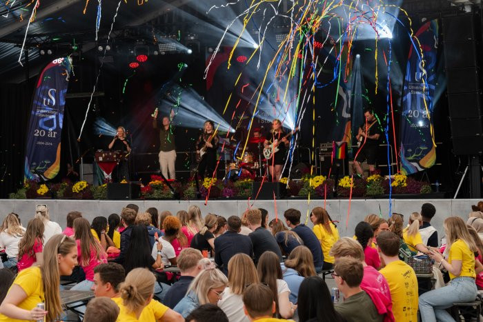 Studenter samlet foran en scene med et band og masse konfetti