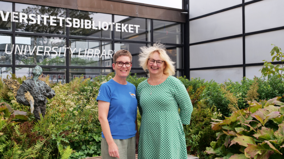 To ansatte står foran biblioteket