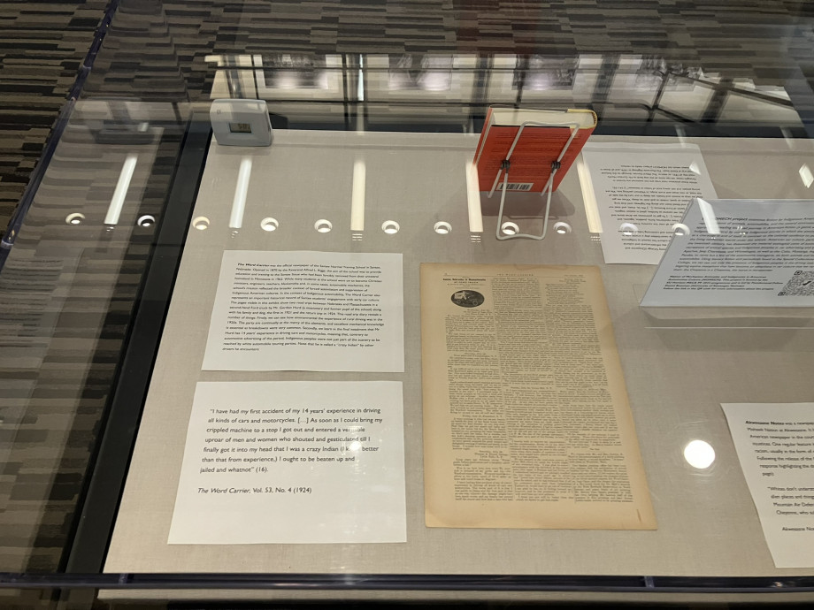 An old newspaper lies flat in a display case