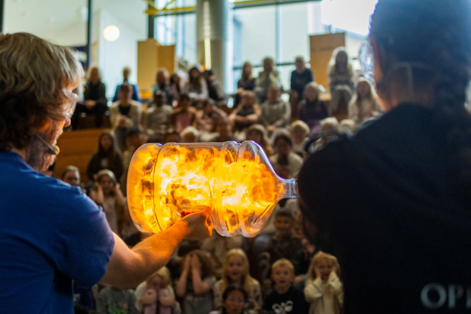 En flaske med flammer holdes mot publikum